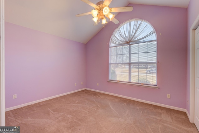 carpeted spare room featuring vaulted ceiling and ceiling fan