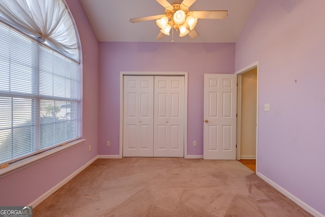 unfurnished bedroom with ceiling fan, light colored carpet, and a closet