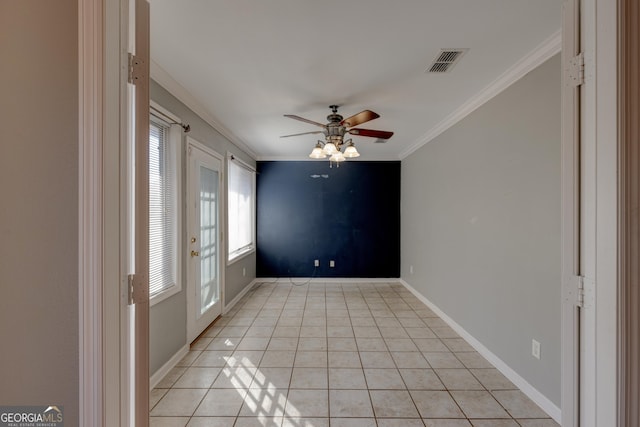 empty room with ceiling fan, light tile patterned floors, and ornamental molding