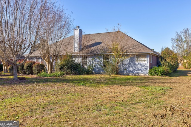 rear view of property featuring a lawn