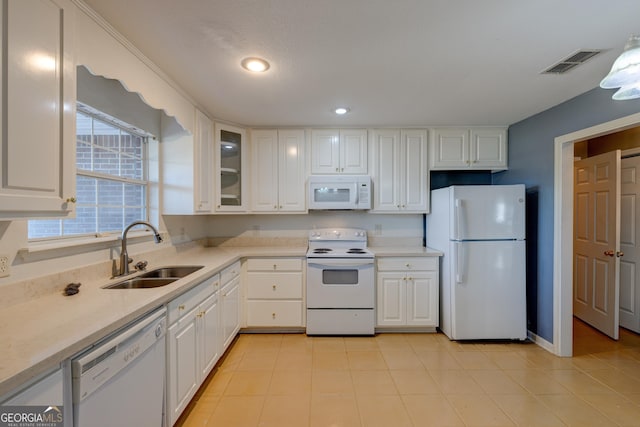 kitchen featuring sink, white cabinets, and white appliances