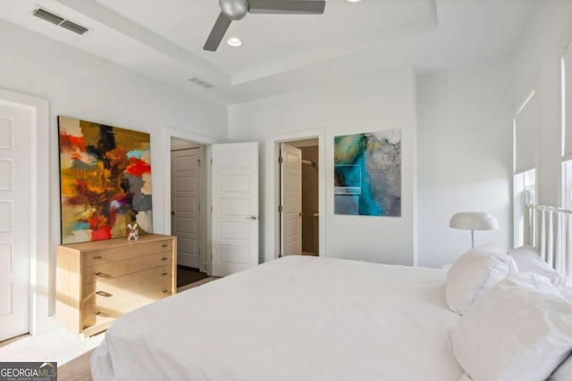 bedroom with a tray ceiling and ceiling fan