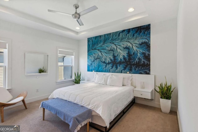 bedroom featuring a tray ceiling, ceiling fan, and carpet flooring