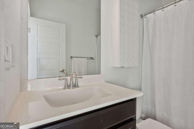 bathroom featuring vanity, curtained shower, and toilet