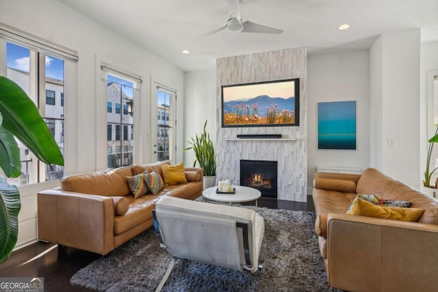 living room featuring a fireplace, plenty of natural light, dark wood-type flooring, and ceiling fan