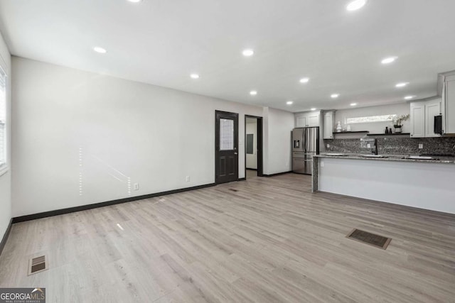 kitchen featuring sink, white cabinets, light hardwood / wood-style floors, and stainless steel refrigerator with ice dispenser