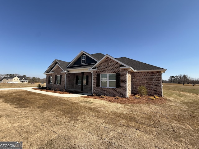 craftsman inspired home featuring a front lawn and brick siding