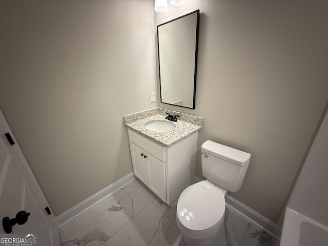 half bath featuring toilet, marble finish floor, vanity, and baseboards