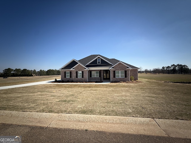 craftsman-style house featuring a front lawn and brick siding