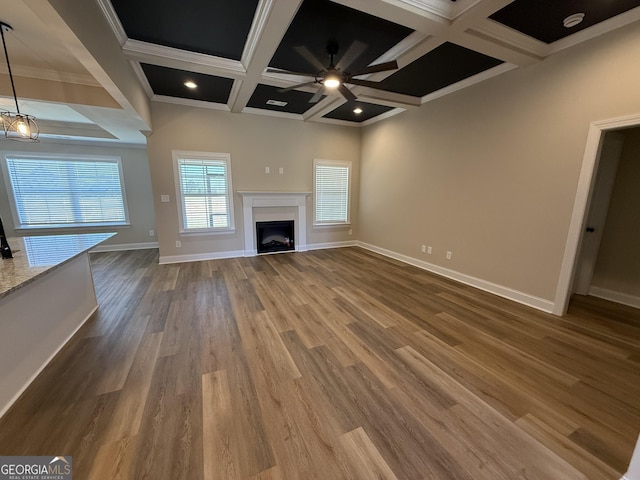 unfurnished living room with a fireplace, ceiling fan, wood finished floors, coffered ceiling, and baseboards