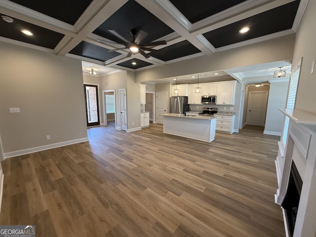 kitchen with decorative light fixtures, stainless steel appliances, light countertops, a ceiling fan, and white cabinetry