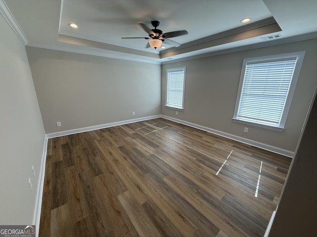 spare room with baseboards, a tray ceiling, and ornamental molding