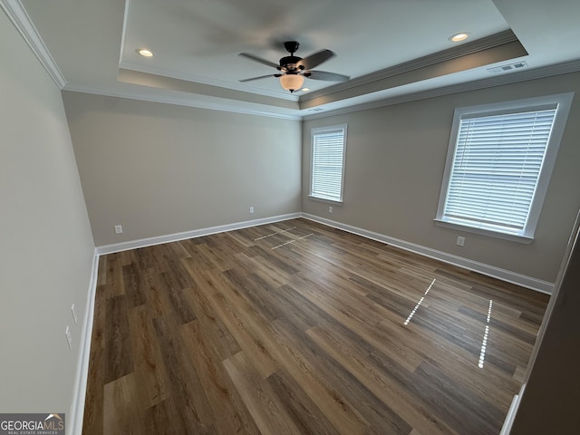 spare room featuring a tray ceiling, visible vents, and baseboards