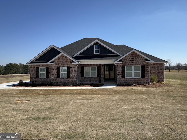 craftsman house featuring a front yard and brick siding