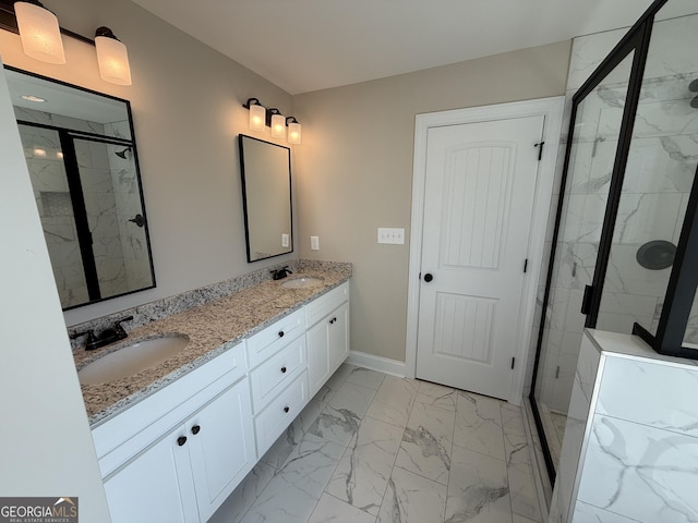 full bath with marble finish floor, double vanity, a stall shower, a sink, and baseboards