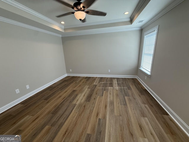 unfurnished room featuring ornamental molding, a tray ceiling, visible vents, and baseboards