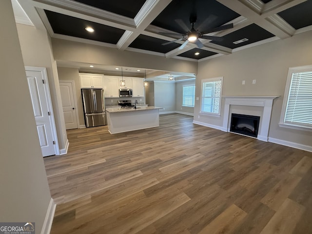 kitchen featuring white cabinets, ceiling fan, open floor plan, decorative light fixtures, and stainless steel appliances