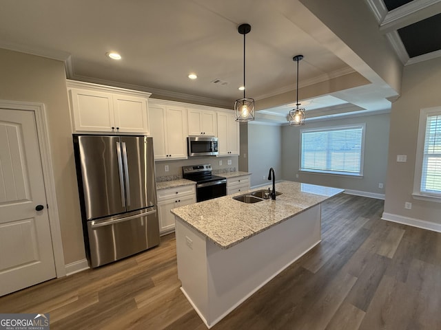 kitchen with appliances with stainless steel finishes, white cabinets, a sink, and a center island with sink