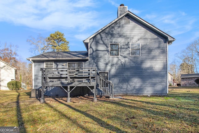 rear view of house featuring a lawn and a deck