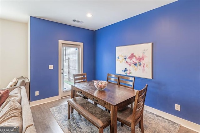 dining space with wood-type flooring