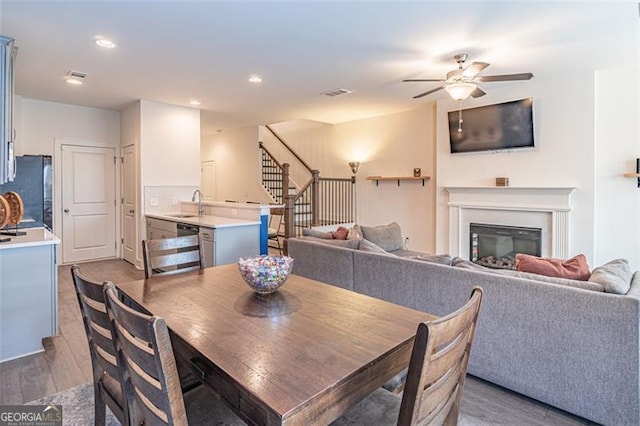 dining room featuring light wood-type flooring, ceiling fan, and sink