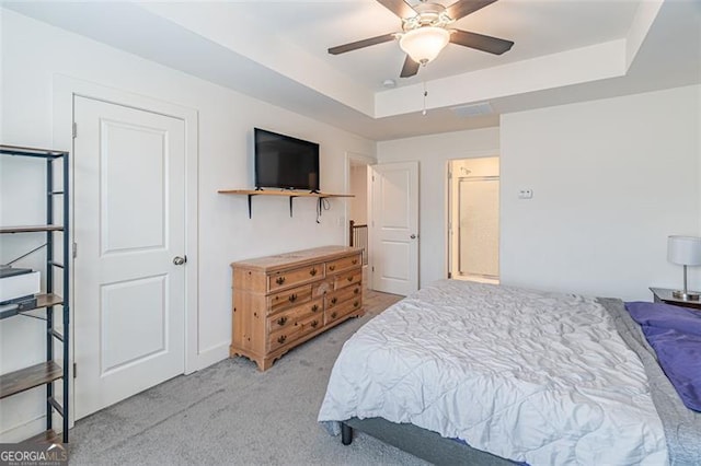 bedroom with a raised ceiling, ceiling fan, and light carpet