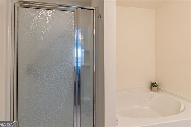 bathroom featuring shower with separate bathtub