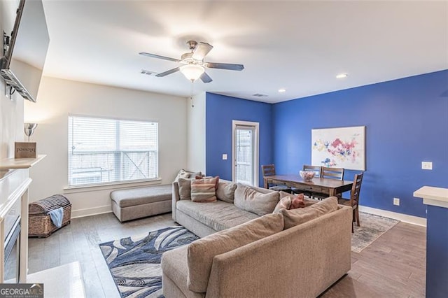 living room with wood-type flooring, plenty of natural light, and ceiling fan