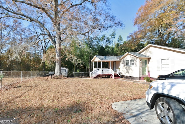 view of front of house featuring covered porch and a shed