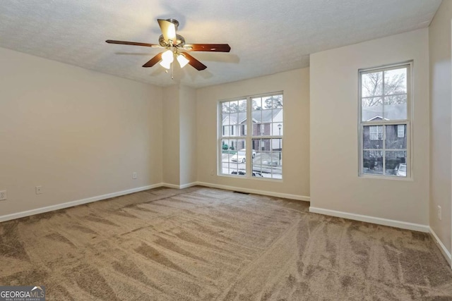 carpeted empty room featuring ceiling fan and a textured ceiling