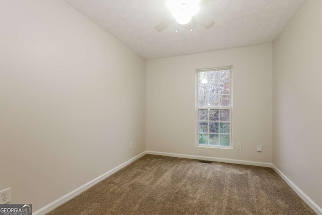 carpeted spare room featuring ceiling fan, plenty of natural light, and a textured ceiling