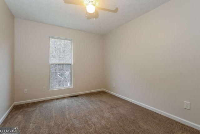 carpeted empty room featuring ceiling fan and a textured ceiling