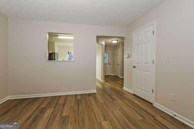 unfurnished room with hardwood / wood-style floors and a textured ceiling