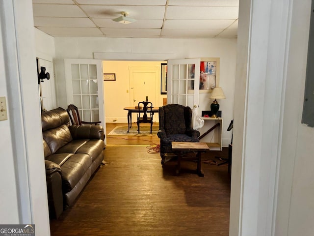 living room with hardwood / wood-style flooring and a paneled ceiling