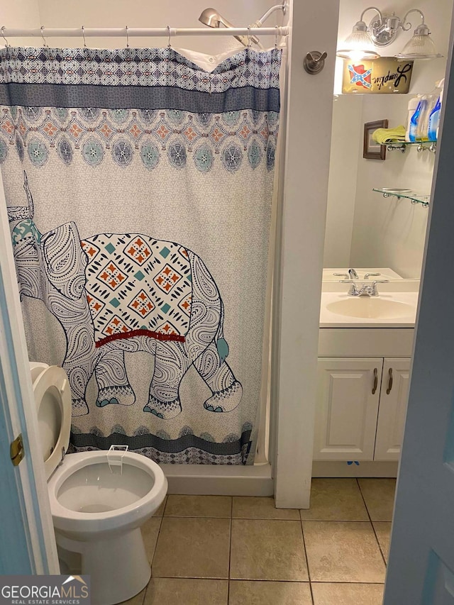 bathroom with tile patterned flooring, walk in shower, vanity, and toilet