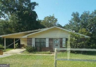 view of front of house with a front yard and a carport