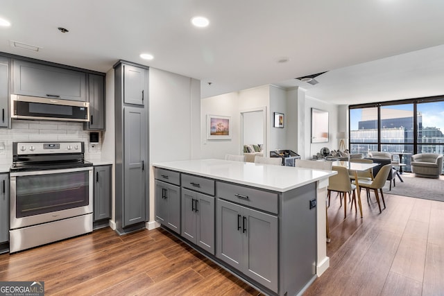 kitchen with gray cabinetry, kitchen peninsula, and appliances with stainless steel finishes