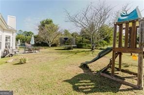 view of yard with a playground and a trampoline