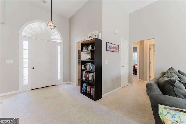 carpeted entryway with high vaulted ceiling