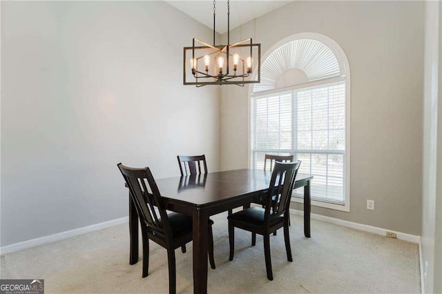 dining space featuring light carpet and a chandelier