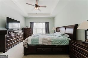 bedroom with a tray ceiling and ceiling fan