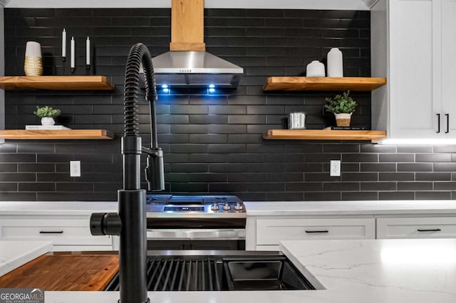 kitchen featuring decorative backsplash, white cabinetry, and light stone counters