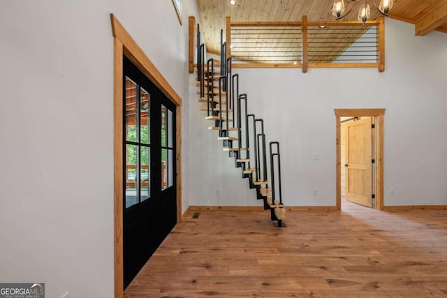 foyer entrance featuring light hardwood / wood-style floors, wooden ceiling, beam ceiling, and high vaulted ceiling