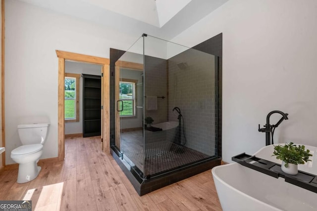 bathroom featuring hardwood / wood-style floors, toilet, and shower with separate bathtub