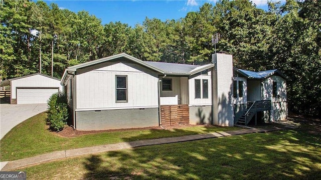 view of front of house featuring a garage, an outbuilding, and a front yard