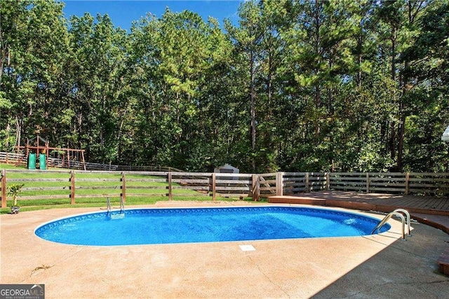 view of pool with a patio and a playground