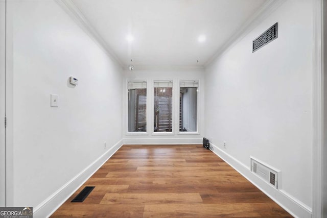 unfurnished room featuring ornamental molding and hardwood / wood-style floors