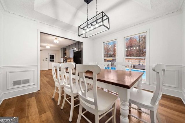 dining area with crown molding and dark hardwood / wood-style floors