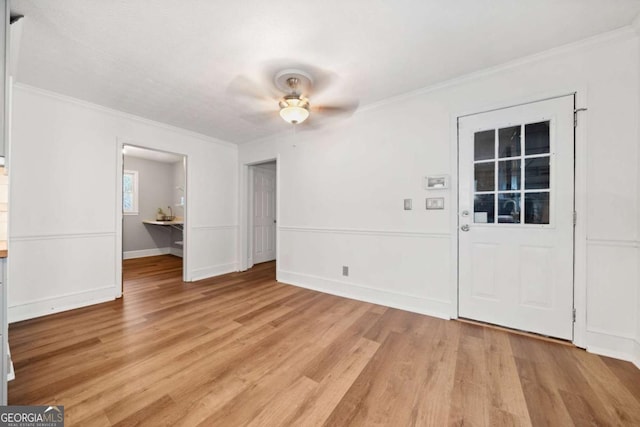 interior space with ceiling fan, light hardwood / wood-style flooring, and crown molding