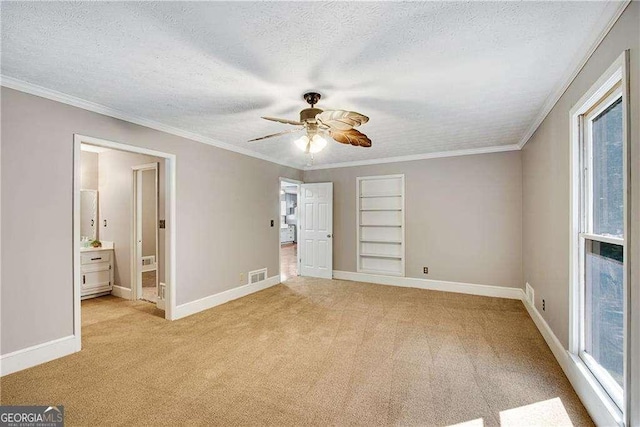 unfurnished bedroom with a textured ceiling, ceiling fan, crown molding, connected bathroom, and light carpet